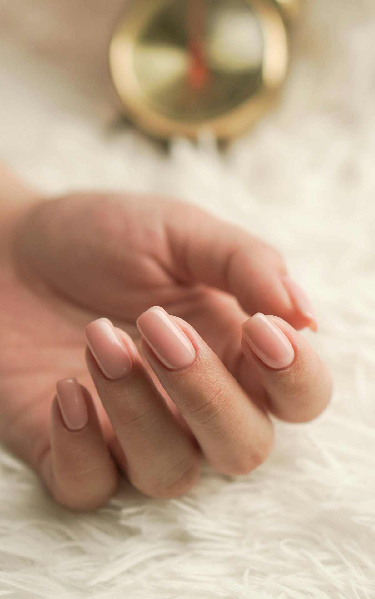 Main aux ongles nude parfaitement manucurés